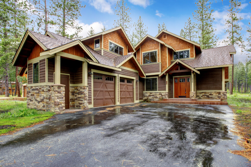 Painting Your Home Exterior Large mountain cabin house with stone and driveway after rain.